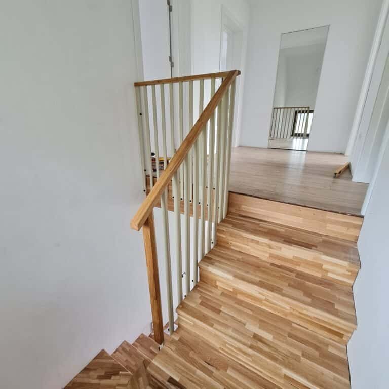 Ușă interioară și scară din lemn în casă modernă, cu pardoseală din lemn natural și balustradă din l.