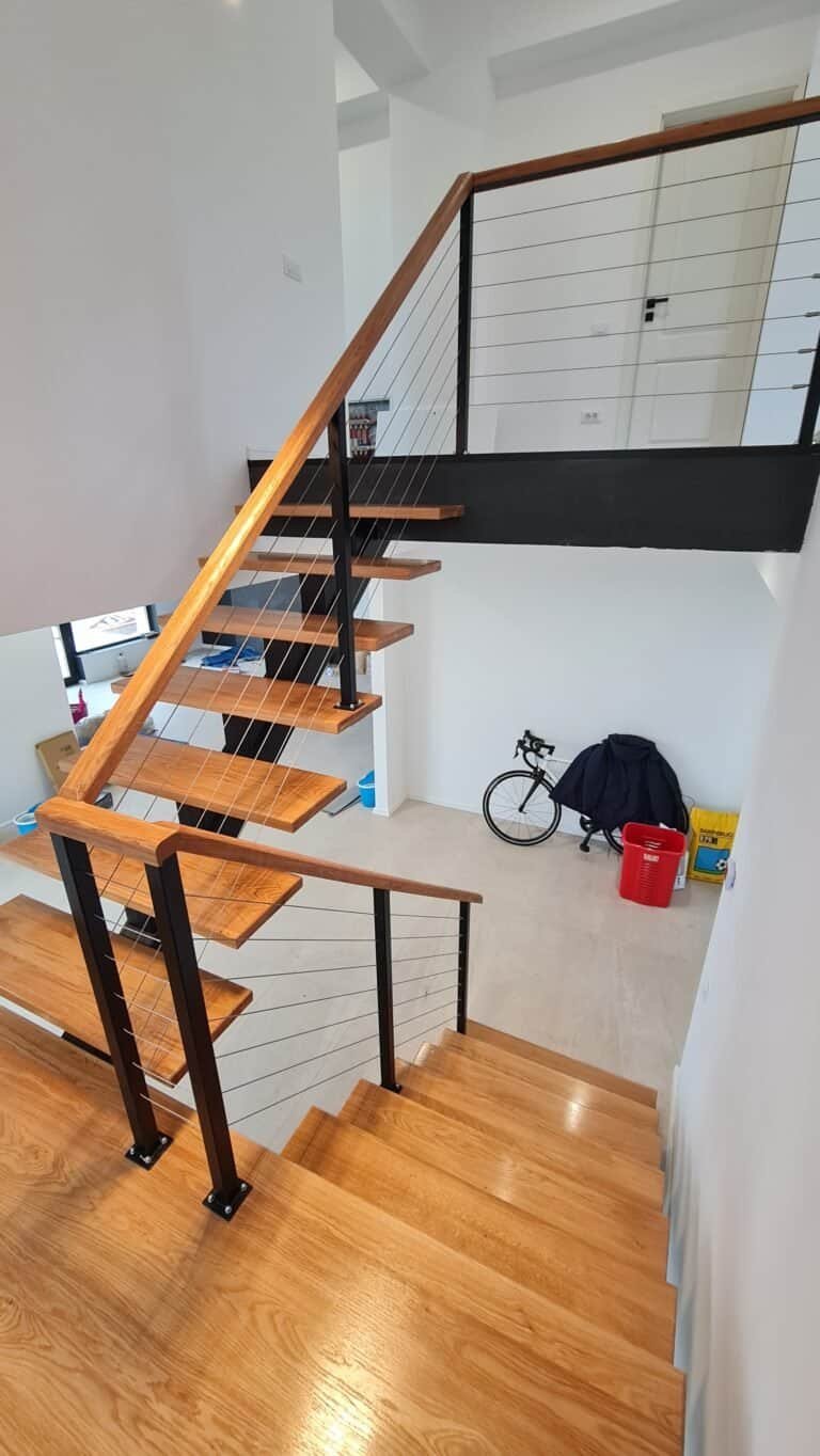 Scară interioară din lemn și metal, design modern, spațiu luminos, element decorativ elegant.