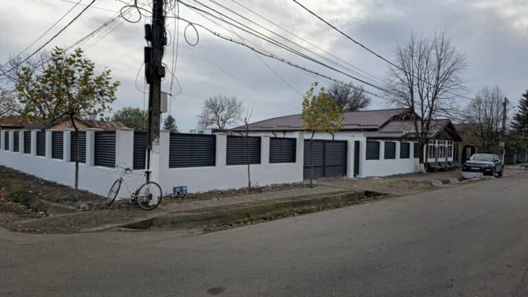 Zid de protecție alb cu panouri negre pentru curte și grădină.