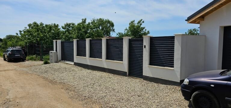 Poartă metalică modernă și ziduri înalte pentru securitate și intimitate.