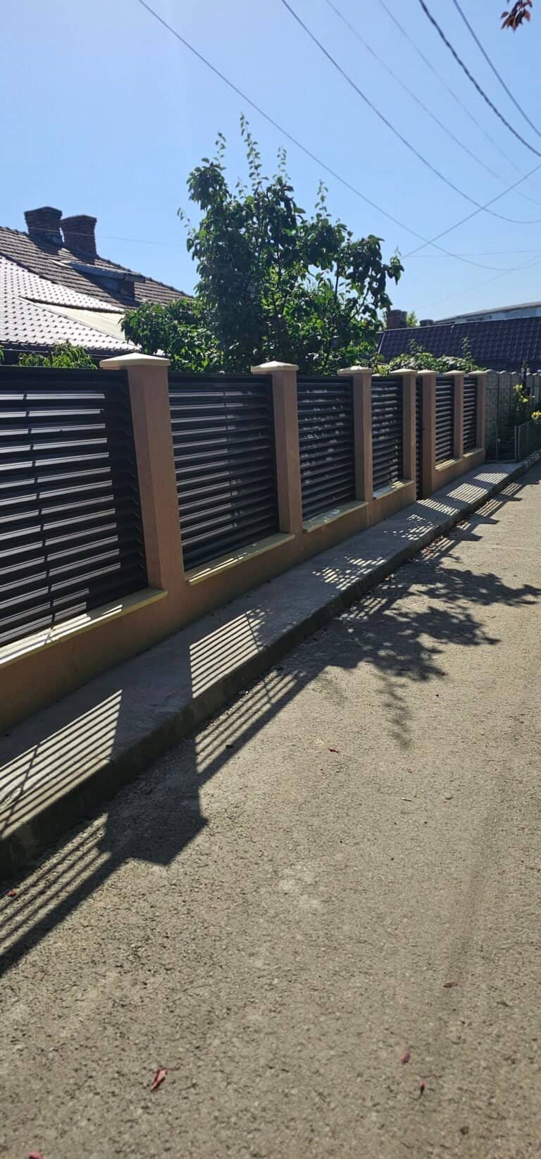 Gard din lemn modern cu stâlpi de beton, ideal pentru delimitarea și protecția proprietății.