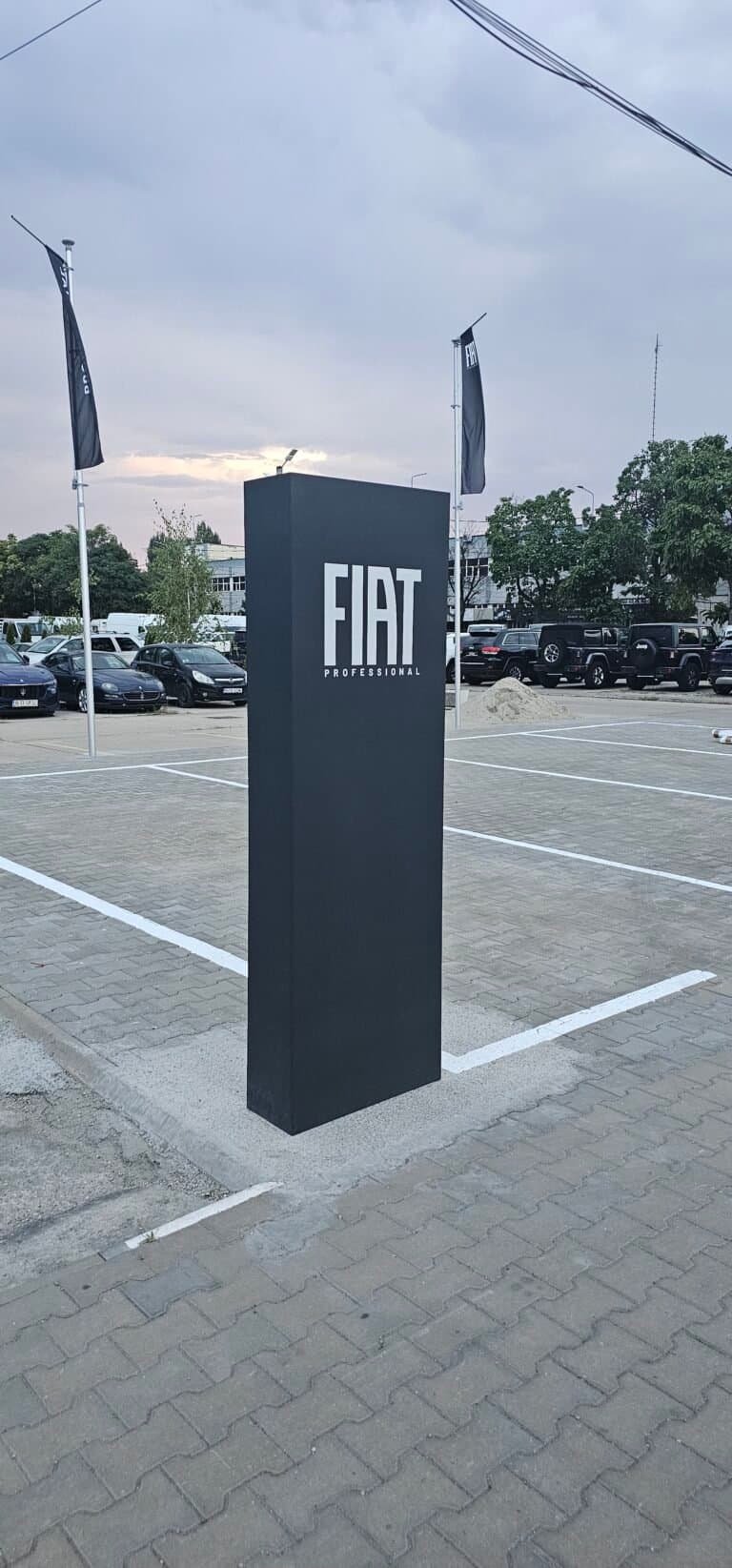 Sigla Fiat pe un panou de prezentare în parcarea auto.