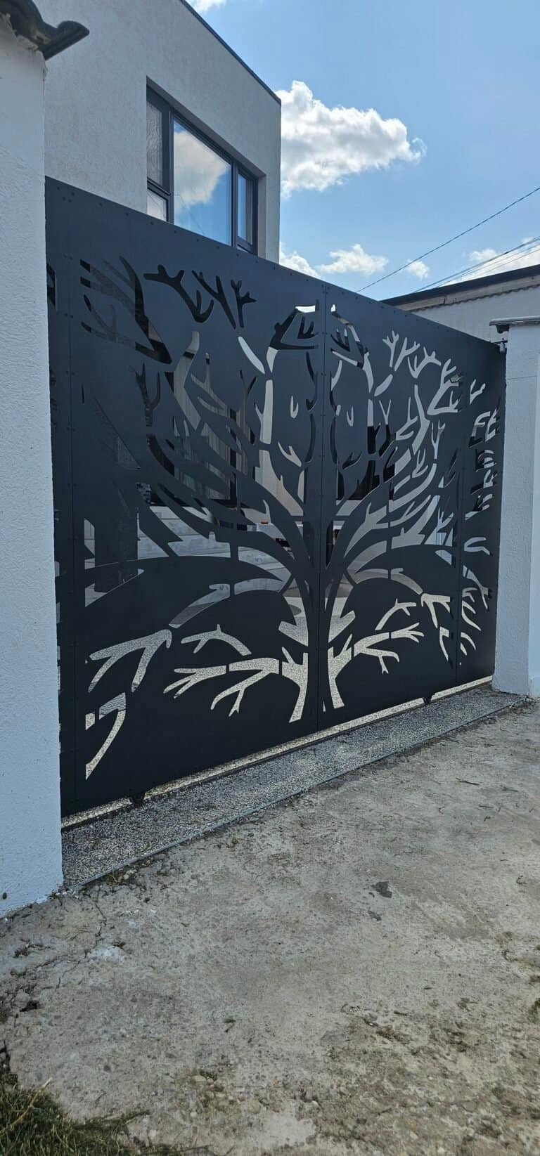 Gard metalic cu design de copac stilizat.