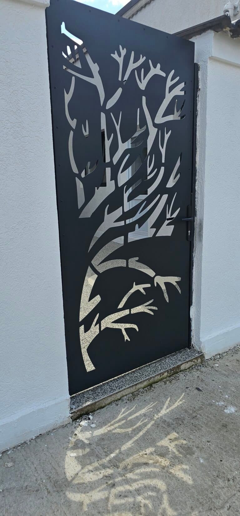Poartă metalică decorativă cu model de copac stilizat.