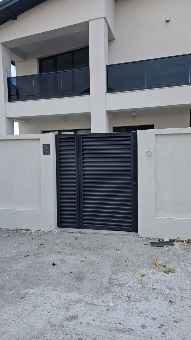 Ușă de grădină modernă, neagră, din metal, cu design vertical.