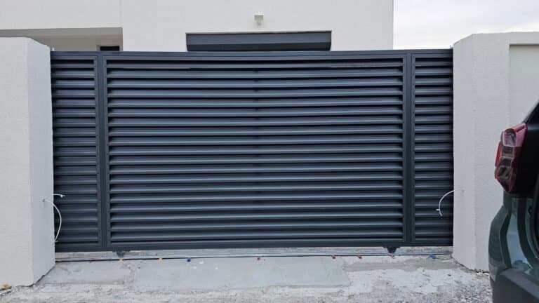 Poartă de garaj din metal gri, modernă și durabilă, ideală pentru securizarea și estetică.