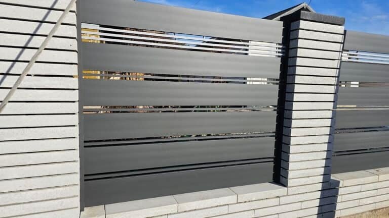 Gard modern din metal și beton pentru securitate și estetică.