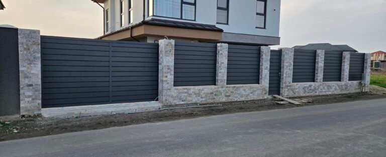 Poartă metalică de grădină cu ziduri din beton și finisaj modern.