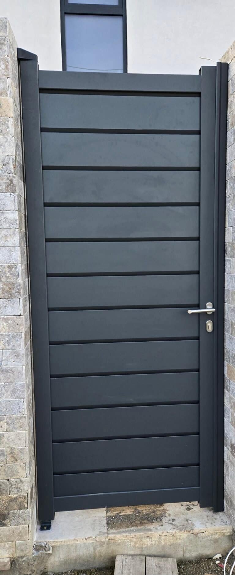 Ușă de grădină din lemn compozit, culoare gri închis, cu mâner și încuietoare moderne.