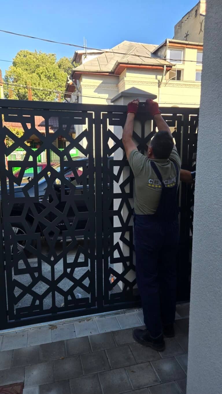 Muncitor instalând o ușă metalică cu model geometric modern.