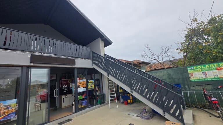 Imaginea prezintă un magazin cu o scară exterioară și automatizare pentru acces facil.